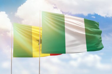 Sunny blue sky and flags of nigeria and senegal