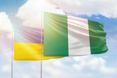 Sunny blue sky and flags of nigeria and ukraine