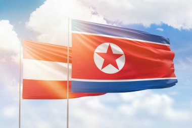 Sunny blue sky and flags of north korea and austria
