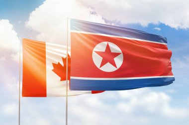 Sunny blue sky and flags of north korea and canada