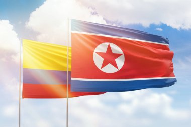 Sunny blue sky and flags of north korea and colombia