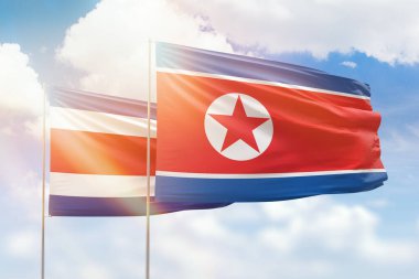 Sunny blue sky and flags of north korea and costa rica