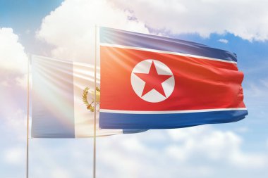 Sunny blue sky and flags of north korea and guatemala