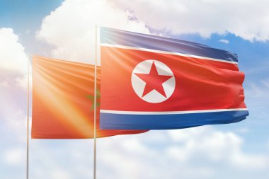 Sunny blue sky and flags of north korea and morocco