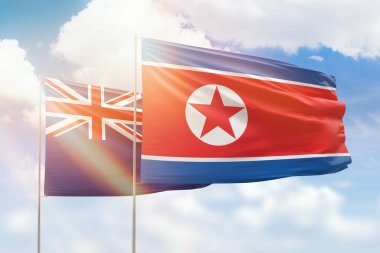 Sunny blue sky and flags of north korea and new zealand