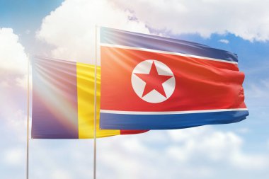 Sunny blue sky and flags of north korea and romania