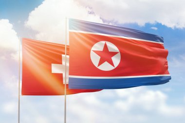 Sunny blue sky and flags of north korea and switzerland