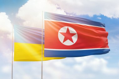 Sunny blue sky and flags of north korea and ukraine