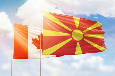 Sunny blue sky and flags of north macedonia and canada