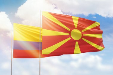 Sunny blue sky and flags of north macedonia and colombia