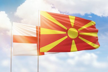 Sunny blue sky and flags of north macedonia and england