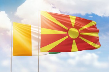 Sunny blue sky and flags of north macedonia and ivory coast