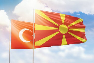 Sunny blue sky and flags of north macedonia and turkey