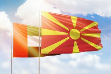 Sunny blue sky and flags of north macedonia and uae