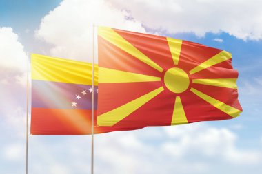 Sunny blue sky and flags of north macedonia and venezuela