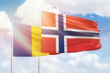 Sunny blue sky and flags of norway and romania