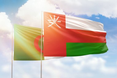 Sunny blue sky and flags of oman and algeria