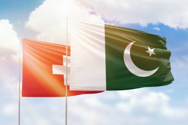 Sunny blue sky and flags of pakistan and switzerland