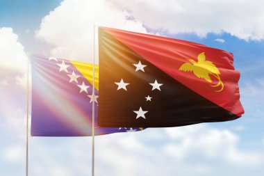 Sunny blue sky and flags of papua new guinea and bosnia