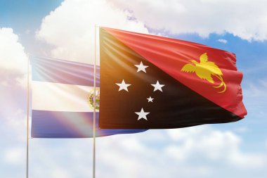 Sunny blue sky and flags of papua new guinea and el salvador