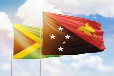 Sunny blue sky and flags of papua new guinea and jamaica