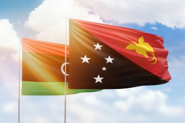 Sunny blue sky and flags of papua new guinea and libya