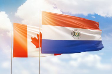 Sunny blue sky and flags of paraguay and canada