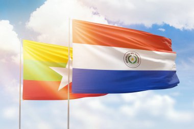 Sunny blue sky and flags of paraguay and myanmar