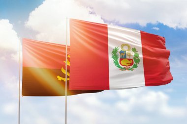 Sunny blue sky and flags of peru and angola