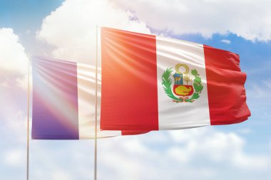 Sunny blue sky and flags of peru and france