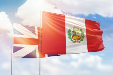 Sunny blue sky and flags of peru and great britain