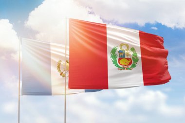 Sunny blue sky and flags of peru and guatemala
