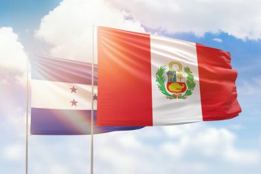 Sunny blue sky and flags of peru and honduras