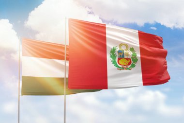 Sunny blue sky and flags of peru and hungary
