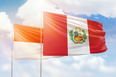 Sunny blue sky and flags of peru and indonesia