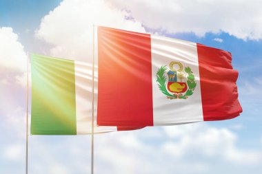 Sunny blue sky and flags of peru and italy
