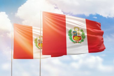 Sunny blue sky and flags of peru and peru
