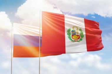 Sunny blue sky and flags of peru and russia
