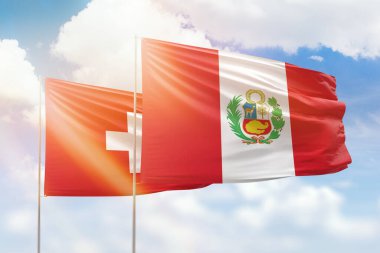 Sunny blue sky and flags of peru and switzerland