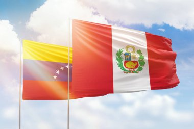 Sunny blue sky and flags of peru and venezuela