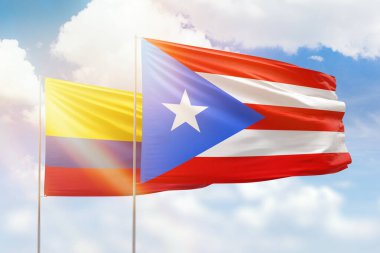 Sunny blue sky and flags of puerto rico and colombia