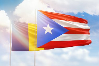 Sunny blue sky and flags of puerto rico and romania