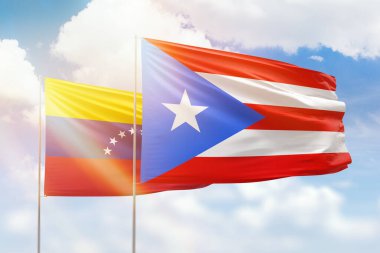 Sunny blue sky and flags of puerto rico and venezuela
