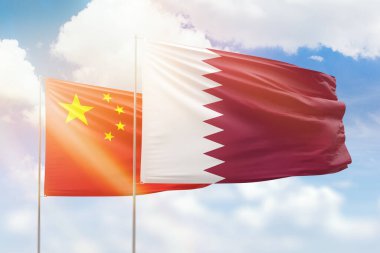 Sunny blue sky and flags of qatar and china