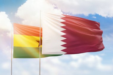 Sunny blue sky and flags of qatar and ghana