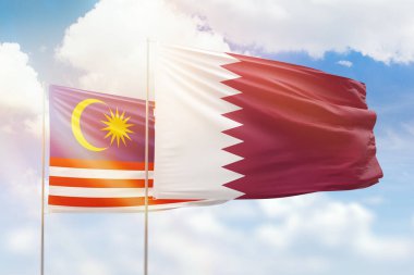 Sunny blue sky and flags of qatar and malaysia