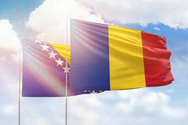 Sunny blue sky and flags of romania and bosnia