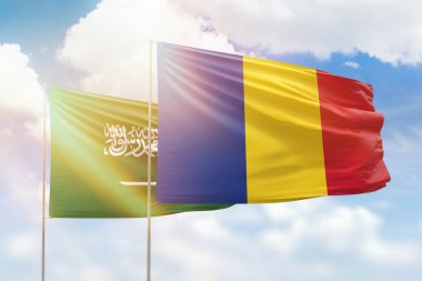 Sunny blue sky and flags of romania and saudi arabia