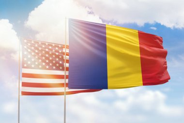 Sunny blue sky and flags of romania and usa