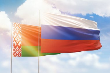 Sunny blue sky and flags of russia and belarus